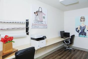 An office with a desk and a printer and a poster on the wall